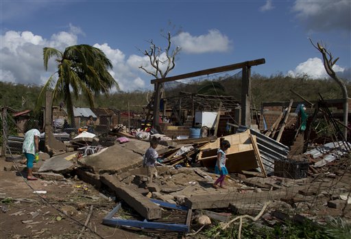 Residents walk through the debris of homes destroyed by Hurricane Patricia, in Chamela, Mexico, Saturday, Oct. 24, 2015. Record-breaking Patricia pushed rapidly inland over mountainous western Mexico early Saturday, weakening to tropical storm force while dumping torrential rains that authorities warned could cause deadly floods and mudslides. (AP Photo/Rebecca Blackwell)