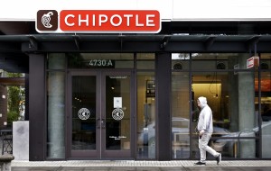 A pedestrian walks past a closed Chipotle restaurant Monday, Nov. 2, 2015, in Seattle. An E. coli outbreak linked to Chipotle restaurants in Washington state and Oregon has sickened nearly two dozen people in the third outbreak of foodborne illness at the popular chain this year. Cases of the bacterial illness were traced to six of the fast-casual Mexican food restaurants, but the company voluntarily closed down 43 of its locations in the two states as a precaution. (AP Photo/Elaine Thompson)