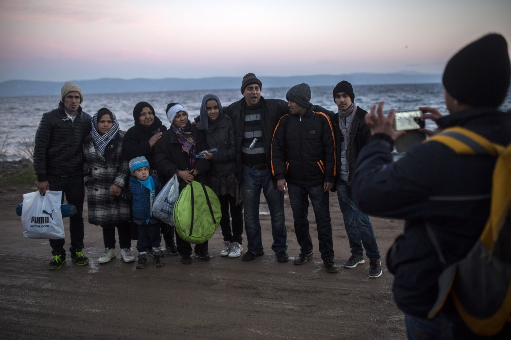 Afghan refugees take a group picture after their arrival on a dinghy, with other refugees and migrants, from Turkish coast to the northeastern Greek island of Lesbos, on Monday, Nov. 30, 2015. The International Organization for Migration said almost 900,000 people fleeing conflict and poverty in the Middle East, Africa and Asia have entered Europe this year seeking sanctuary or jobs. More than 600,000 have entered through Greece, many after making the short sea crossing from Turkey. (AP Photo/Santi Palacios)