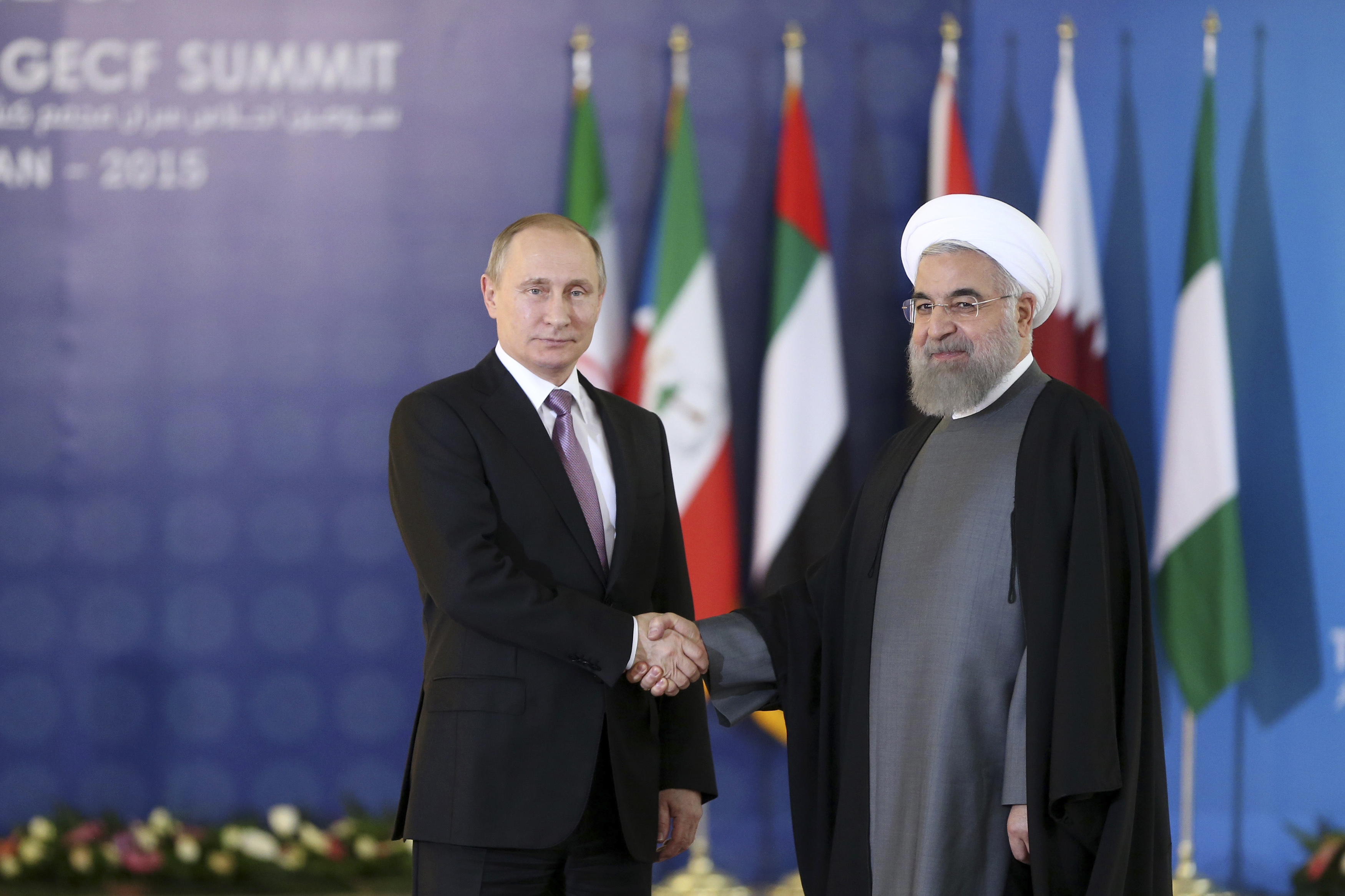 Russian President Vladimir Putin, left, shakes hands with his Iranian counterpart Hassan Rouhani at the Gas Exporting Countries Forum, GECF, summit meeting in Tehran, Iran, Monday, Nov. 23, 2015. (AP Photo/Ebrahim Noroozi)