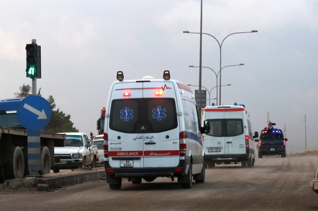 Ambulances leave the King Abdullah bin Al Hussein Training Center where a Jordanian policeman went on a shooting spree in Mwaqar on the outskirts of Amman, Jordan, Monday, Nov. 9, 2015. The policeman opened fire Monday on foreign trainers at a police compound, killing two Americans, a South African and a Jordanian and wounding two Americans and three Jordanians, according to government spokesman Mohammed Momani. (AP Photo/Raad Adayleh)