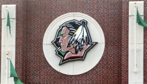 The University of North Dakota's Fighting Sioux logo hangs on Ralph Engelstad Arena in Grand Forks, N.D. The school adopted the nickname the Fighting Hawks on Wednesday, Nov. 18, 2015, to replace the Fighting Sioux. Students across the United States are pressuring their colleges to update mascots, mottos and building names that they say are insensitive. (Associated Press)