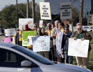 People hold signs during a rally to show support for Muslim members of the community near the Clear Lake Islamic Center in Webster, Texas on Friday, Dec. 4, 2015. Members of several Unitarian Universalist churches and the Unitarian Voices for Justice group showed their support as attendees made their way to the center for Friday prayers. Organizers said the rally was scheduled prior to Wednesday's mass shooting in San Bernardino, Calif. (AP Photo/David J. Phillip)