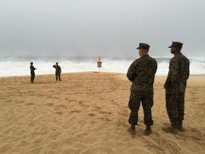 CORRECTS YEAR TO 2016, NOT 2106 - U.S. Marines walk on the beach at Waimea Bay near Haleiwa, Hawaii, where two military helicopters crashed into the ocean about 2 miles offshore, Friday, Jan. 15, 2016. The helicopters carrying 12 crew members collided off the Hawaiian island of Oahu during a nighttime training mission, and rescuers are searching a debris field in choppy waters Friday, military officials said. (Mariana Keller via AP Photo)