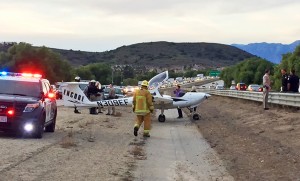 This Monday, Jan. 11, 2016 photo provided by the Ventura County Fire Department shows a two seat airplane after it made an emergency landing on the State Route 23 Freeway in Moorpark, Calif. The California Highway Patrol says vehicles had to swerve to avoid hitting the two-seat aircraft when it touched down after the engine began to sputter. No one was injured.(Ventura County Fire Department via AP)