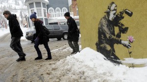 FILE - In this Jan. 22, 2010 file photo, festivalgoers walk up Main Street past a design by graffiti artist Banksy during the Sundance Film Festival in Park City, Utah. The 2016 Sundance film festival runs from Jan. 21-31. (AP Photo/Chris Pizzello, File)
