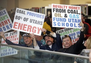 People display their signs during a public hearing to let federal regulators know what they think about a proposal to require more pollution controls at two of the state's oldest coal-fired power plants Tuesday, Jan. 26, 2016, in Salt Lake City. Hundreds of people supporting the coal industry who oppose the plan were in attendance. (AP Photo/Rick Bowmer)