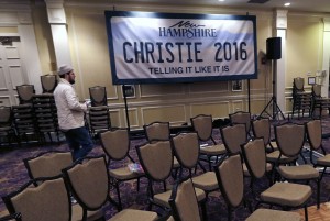 Charlie Pearce, a campaign worker from Orange County, Calif., walks past a "Christie 2016" sign while breaking down the primary night rally stage for Republican presidential candidate, New Jersey Gov. Chris Christie in Nashua, N.H., Wednesday, Feb. 10, 2016. (AP Photo/Charles Krupa)
