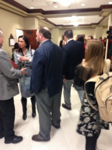 With committee rooms overflowing, citizens wait outside discussing in the hallways. Photo by: David Boyle