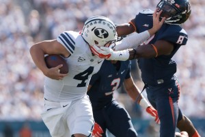 Taysom Hill stiff-arms a Virginia defender in 2014. Hill is returning to BYU for a fifth-year. (Universe Archives)