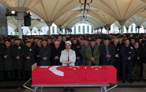 People stand by the Turkish flag-draped coffin of Murat Gul, 20, a security agent killed at Sunday's explosion during his funeral procession in Ankara, Turkey, Monday, March 14, 2016. A senior government official told The Associated Press that authorities believe the attack was carried out by two bombers, one of them a woman, and was the work of Kurdish militants. It was the second deadly attack blamed on Kurdish militants in the capital in the past month. (AP Photo/Burhan Ozbilici)