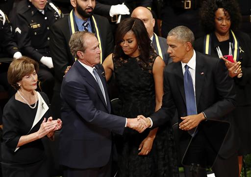 President Barack Obama and former President George W. Bush shake hands as first lady Michelle Obama, and Laura Bush, left, stand by after Bush spoke during a memorial service at the Morton H. Meyerson Symphony Center in Dallas, Tuesday, July 12,2016, for the fallen police officers. Five police officers were killed and several injured during a shooting in downtown Dallas last Thursday night. (AP Photo/Eric Gay)