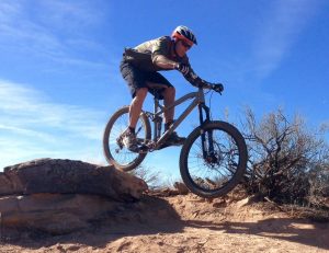 David Lisonbee riding his mountain bike on a trail. 