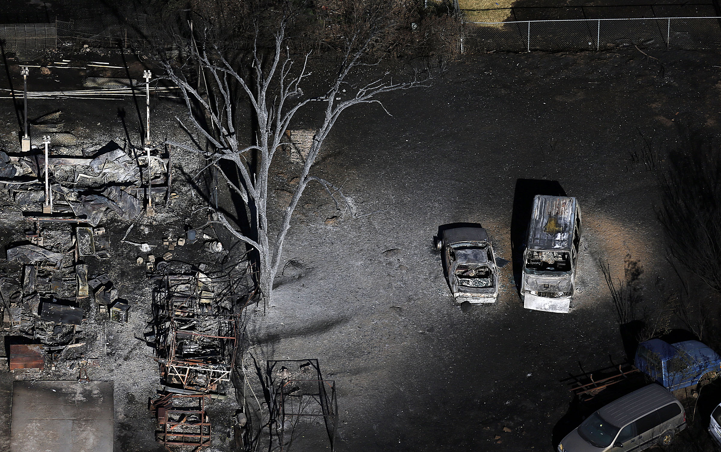 Burnt vehicles and charred debris remain following a fire in Tooele, Utah on Wednesday, July 20, 2016. Firefighters contained a blaze fueled by wind that ripped through a Utah trailer park, displacing dozens of people and destroying multiple homes. (Ravell Call/The Deseret News via AP)