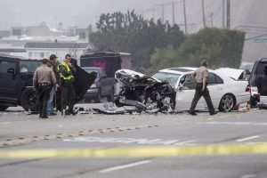 FILE - In this Feb. 7, 2015 file photo, Los Angeles County Sheriff's deputies investigate the scene of a collision involving three vehicles in Malibu, Calif. Officials said former Olympian Bruce Jenner was a passenger in one of the cars involved in the Pacific Coast Highway crash that killed one person. Traffic deaths surged last year as drivers racked up more miles behind the wheel than ever before, a result of an improved economy and lower gas prices, according to preliminary government data released Friday, July 1, 2016. (AP Photo/Ringo H.W. Chiu, File)