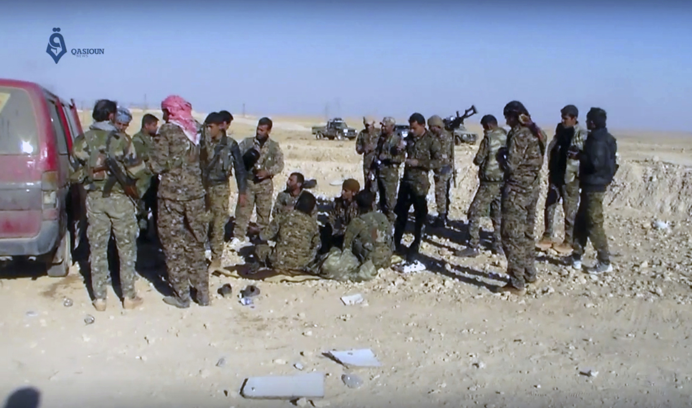 This frame grab from video provided by Qasioun a Syrian opposition media outlet, shows U.S.-backed fighters taking a rest during fighting with the Islamic State group near Ein Issa, north of Raqqa, Syria. Backed by U.S. airstrikes, Kurdish-led Syrian fighters clashed on Monday with Islamic State militants north of the city of Raqqa in Syria as they pushed ahead in their offensive aiming to liberate the city that has been the de facto capital of the extremist group since 2014. (Qasioun a Syrian Opposition Media Outlet, via AP)