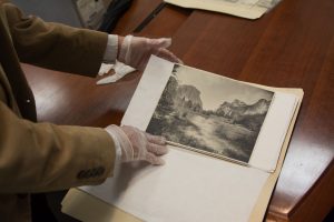 Brock d'Avignon, a BYU alumnus who is helping Pillsbury-Foster, shows a photograph of A.C. Foster's taken in Yosemite National Park. (Ryan Turner)