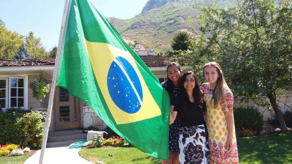 Rebeka Pires poses with her friends from the ELC outside a home with a Brazilian flag in Utah. (Rebeka Pires)