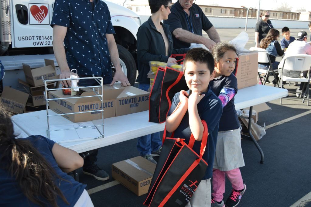 Students receive food from a mobile food pantry at their elementary school. The Utah Food Bank organizes these mobile food pantries to get healthy food to more children. (Utah Food Bank)