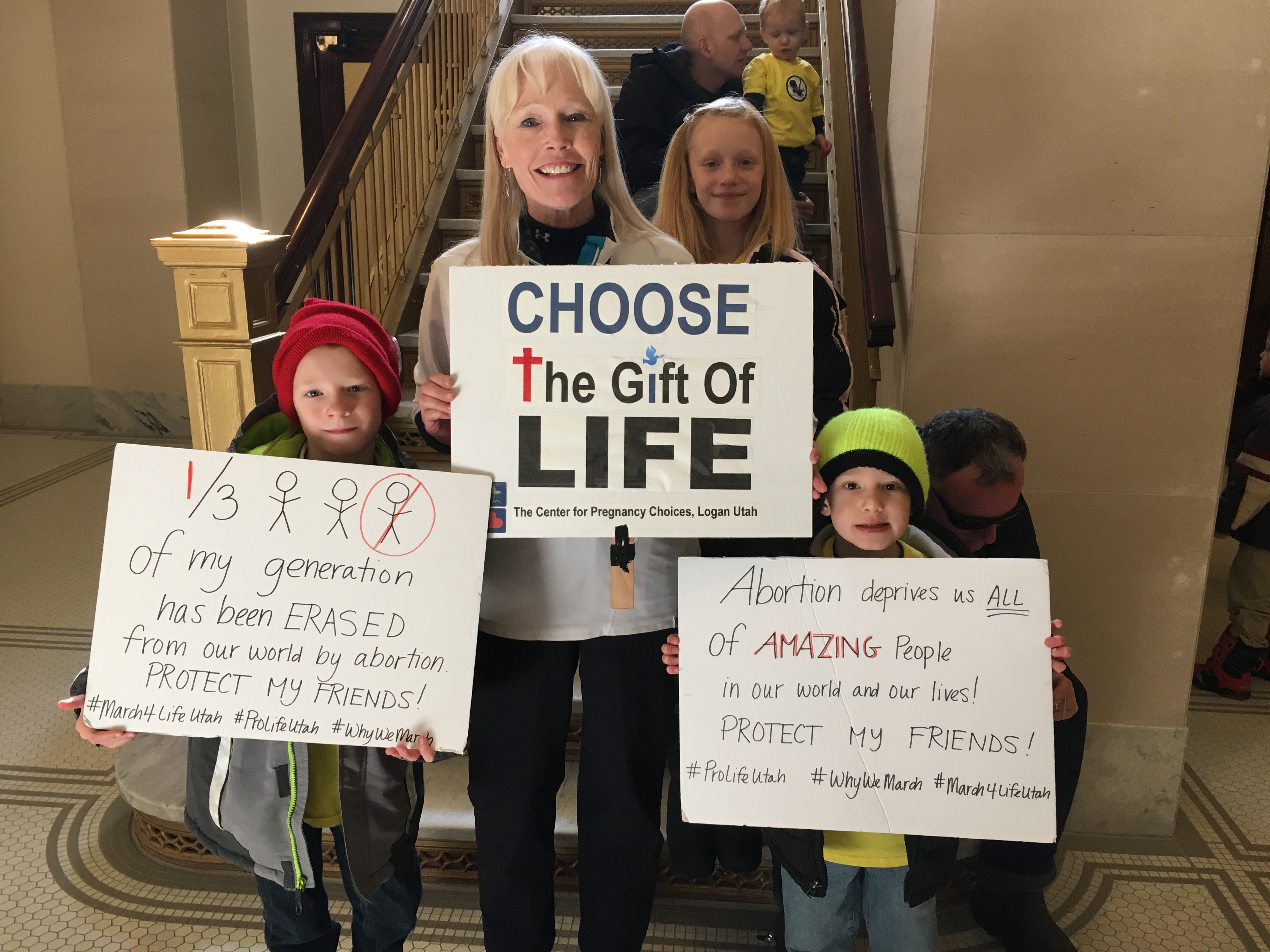 Wendy Shelton from Center for Pregnancy Choices with grandchildren Logan, Jake and Eve Nielsen inside the capitol bill listeining to the speakers. 