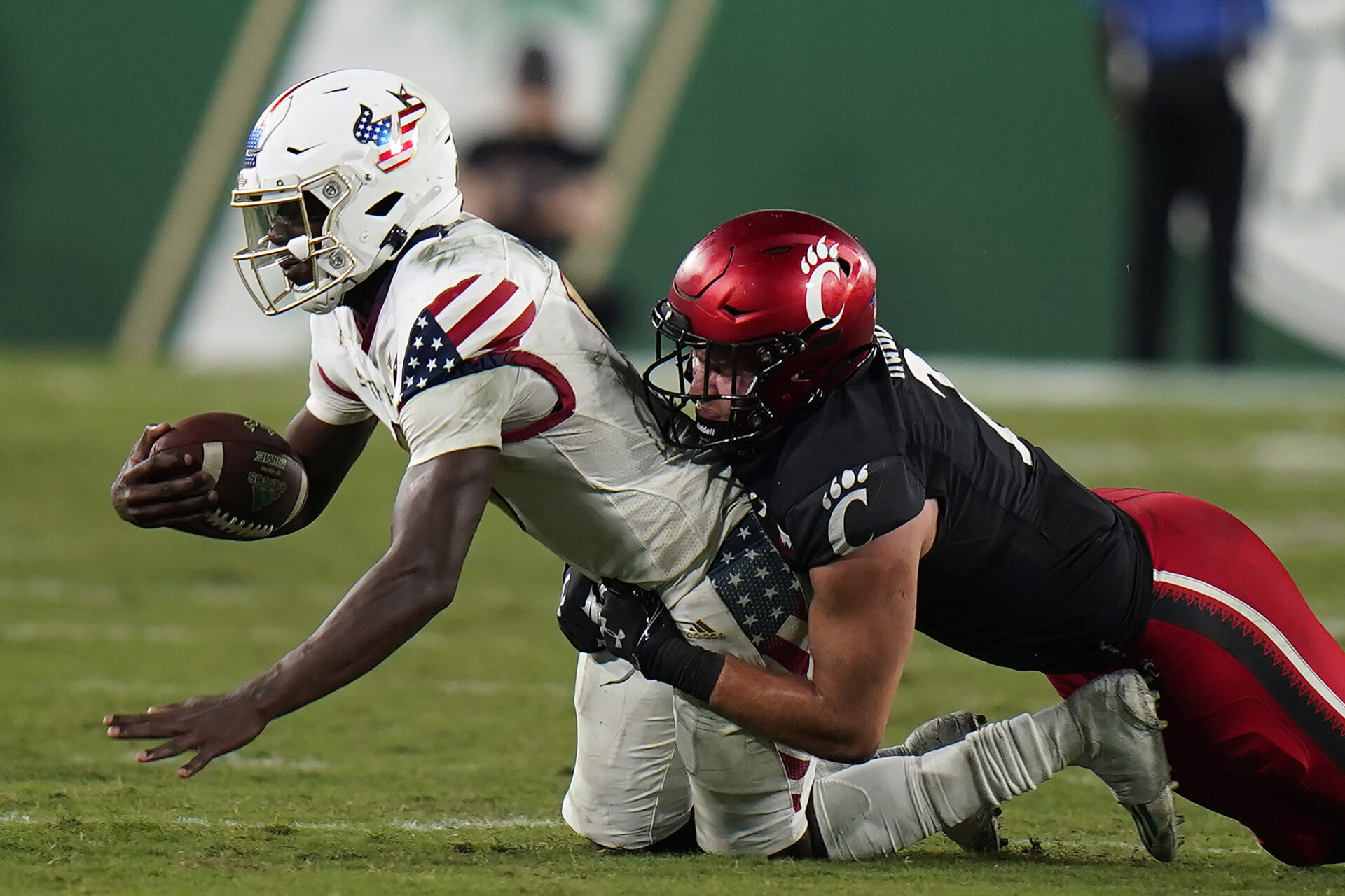 South Florida quarterback Timmy McClain, left, gets sacked by Cincinnati linebacker Wilson Huber during the second half of an NCAA college football game Friday, Nov. 12, 2021, in Tampa, Fla. (AP Photo/Chris O'Meara)
